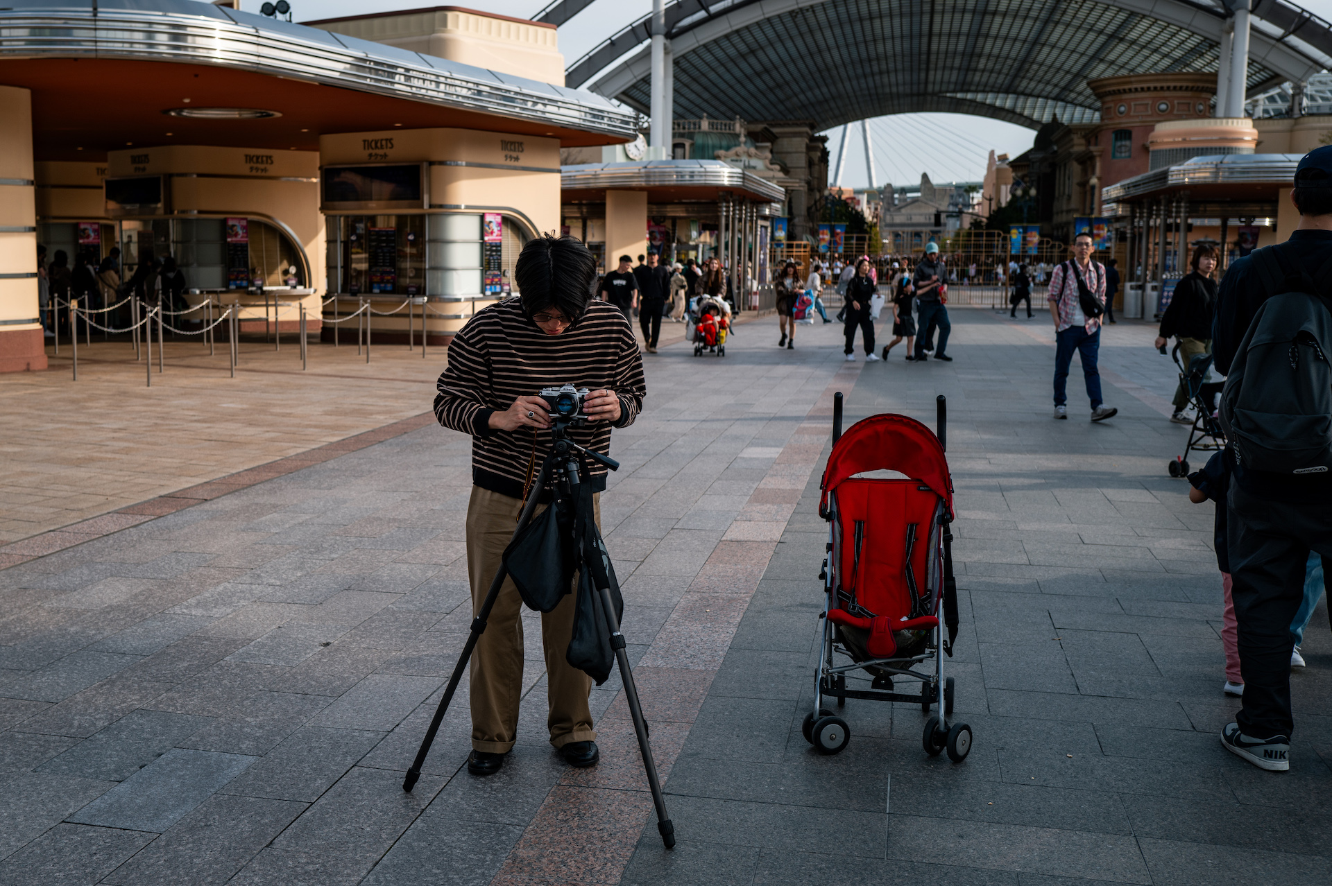 Leica Q3で撮影した作例　テーマパークの大きな通りにスタンドにフィルムカメラをセットする男性